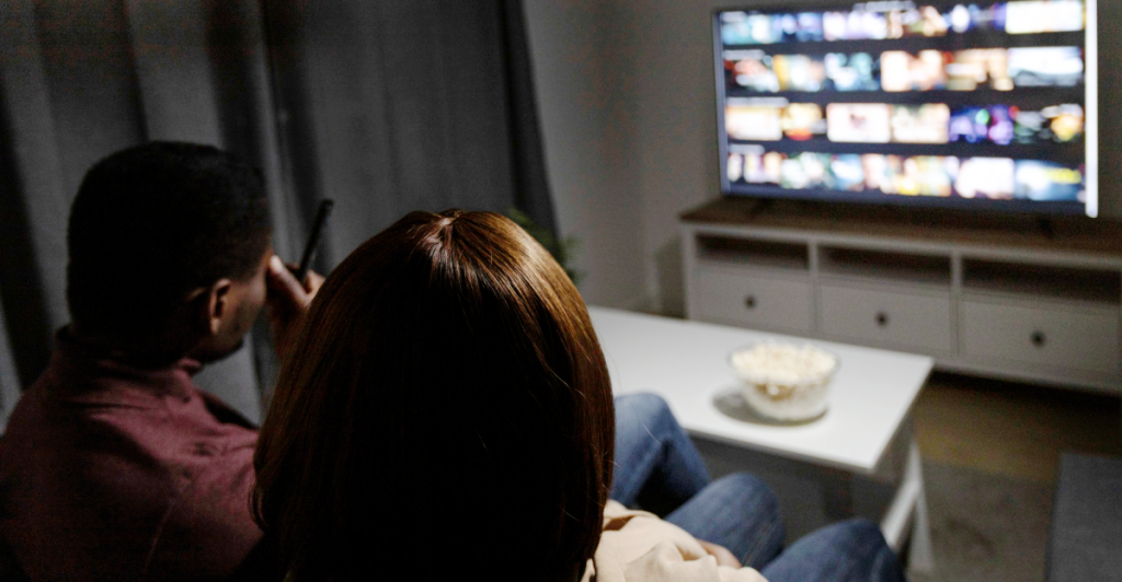 Casal assistindo televisão na sala de estar