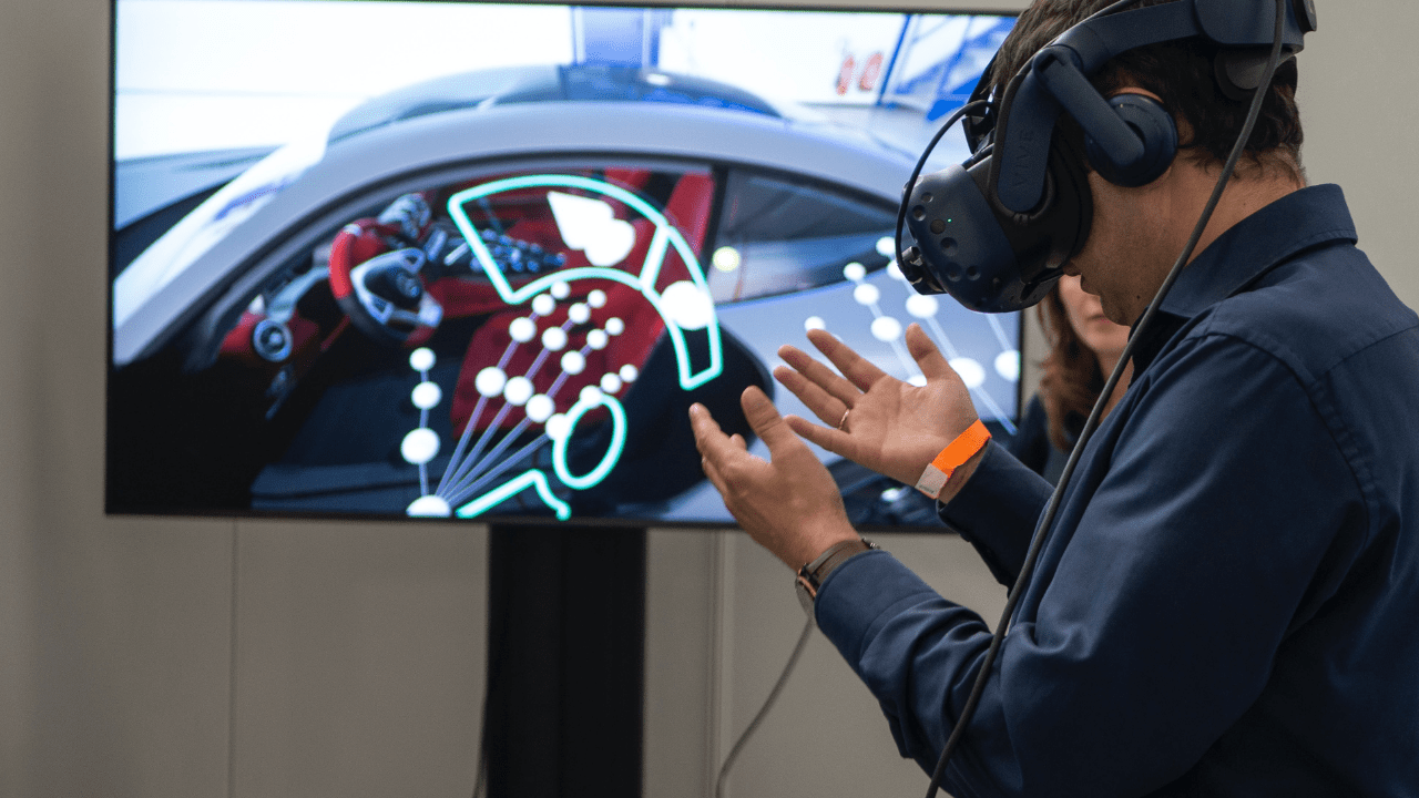 Homem testando óculos VR conectado ao carro (Imagem: Xr Expo/Unsplash)
