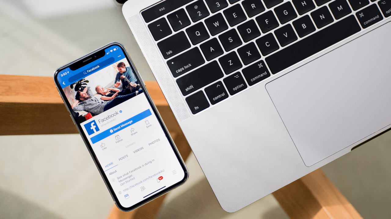 Celular conectado ao Facebook ao lado de Notebook (Imagem: Timothy Hales Bennett/Unsplash)