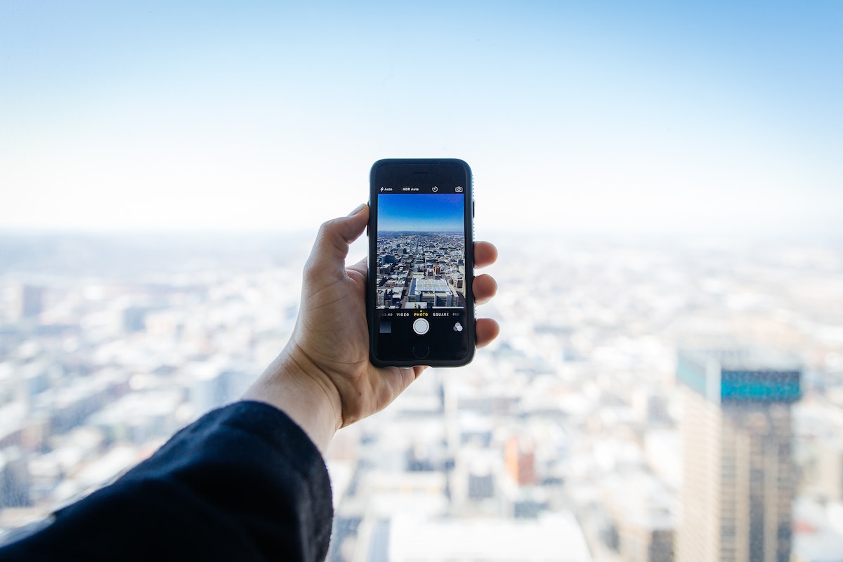 Homem tirando foto do alto de um prédio 