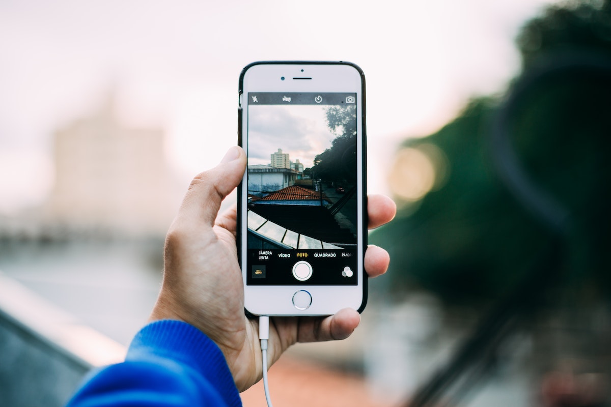 Homem tirando foto da paisagem em um iPhone