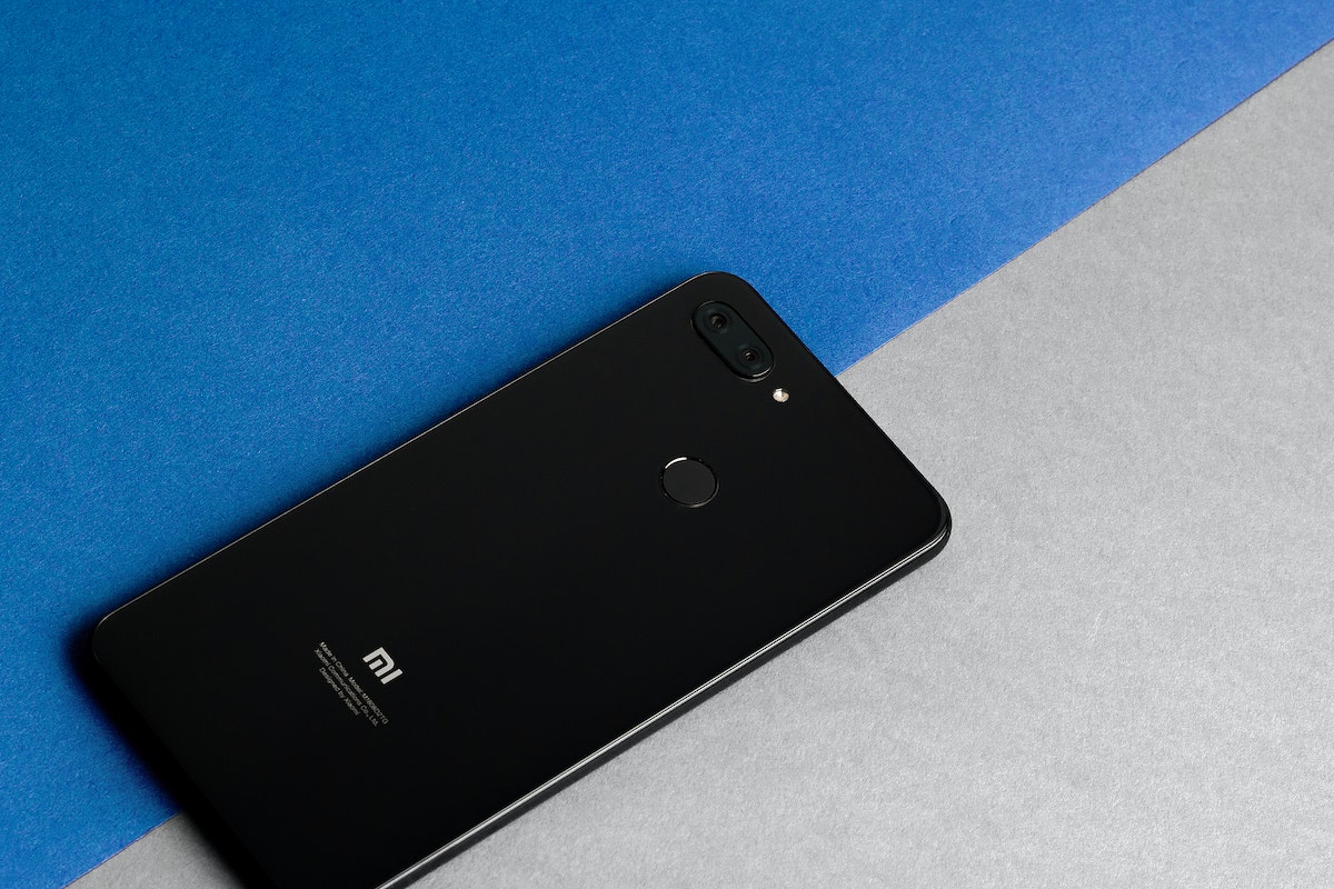 Celular da Xiaomi sobre uma superfície azul e cinza