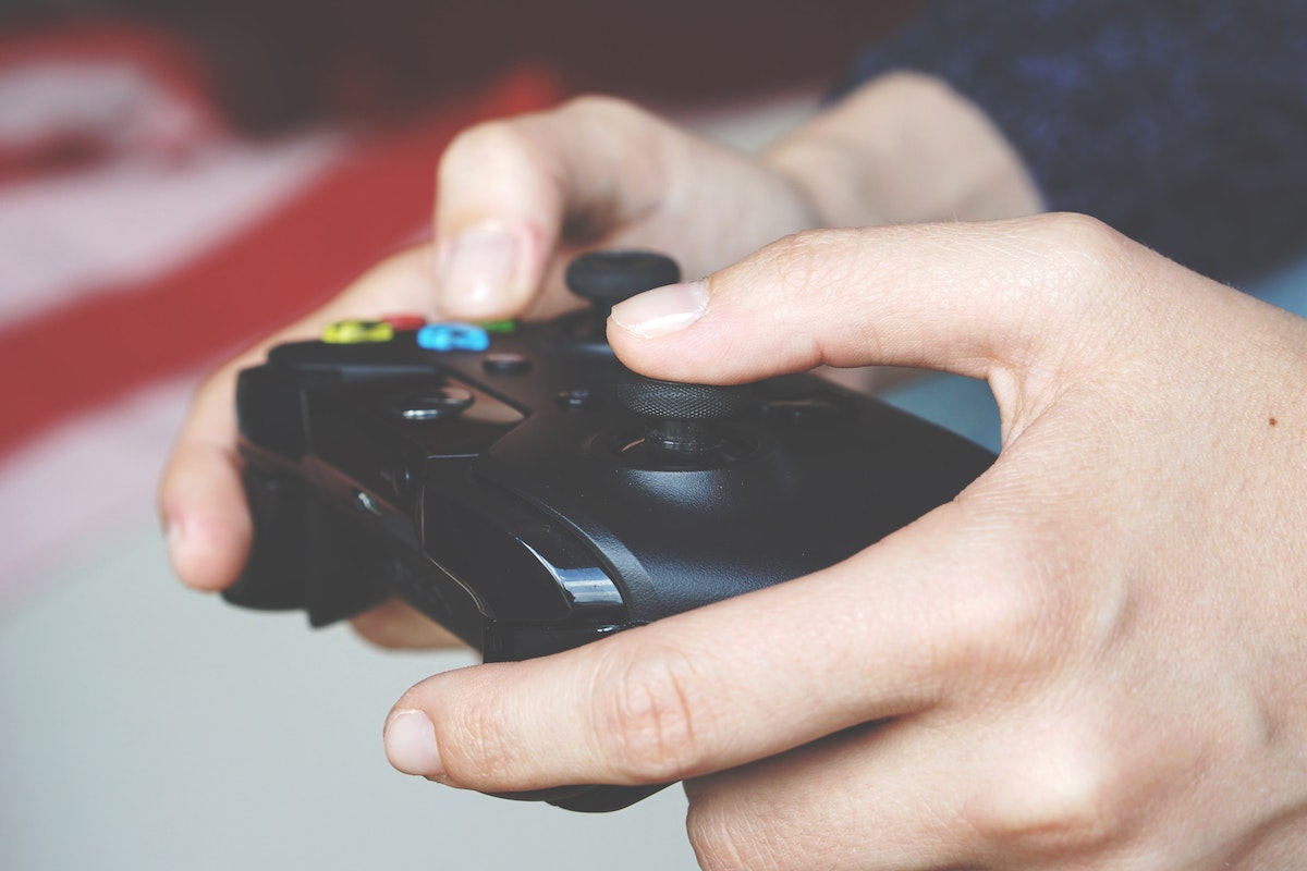 Uma pessoa segura um controlador de videogame Xbox Series X preto em suas mãos.