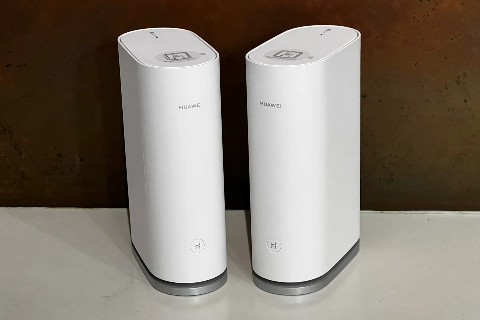 Dois roteadores Huawei Wifi Mesh 3 encima de uma bancada