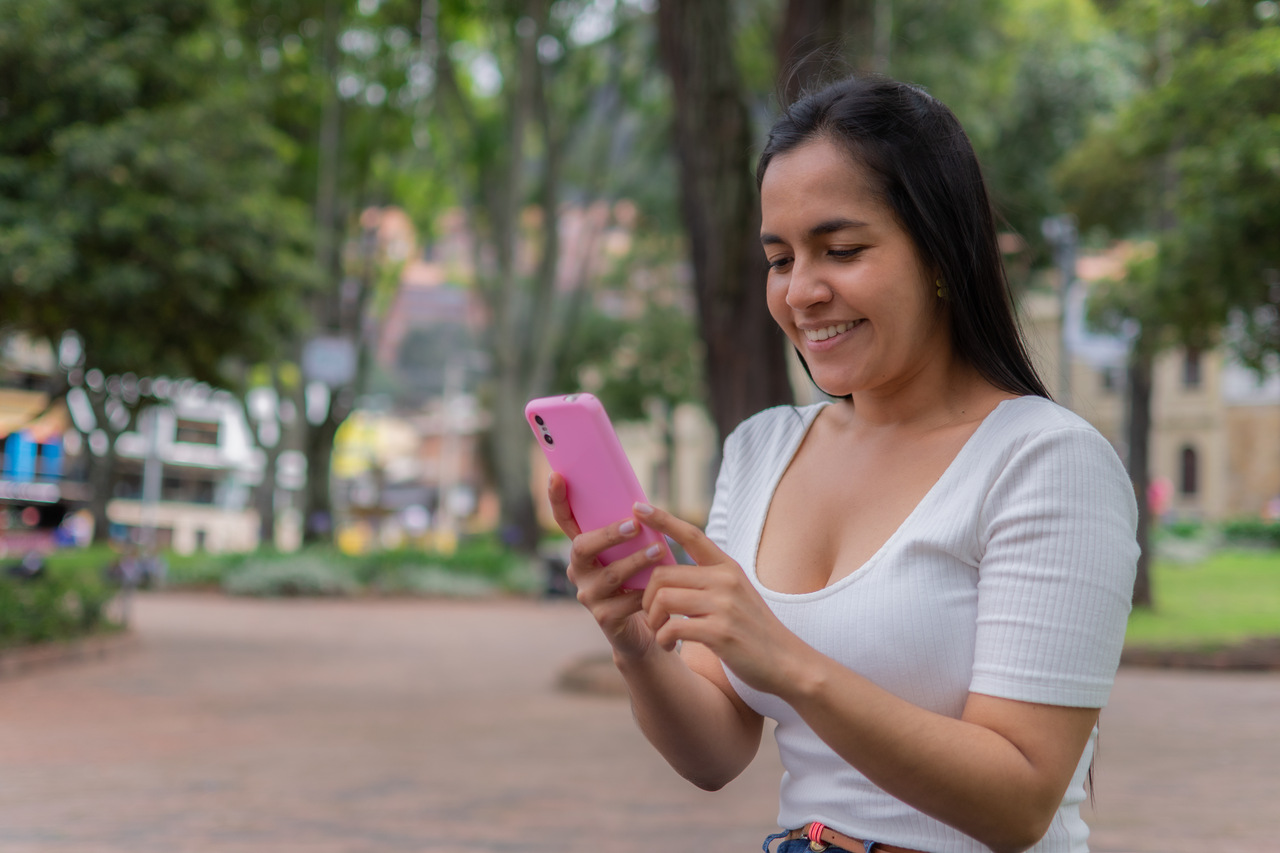 Mulher em parque usando celular