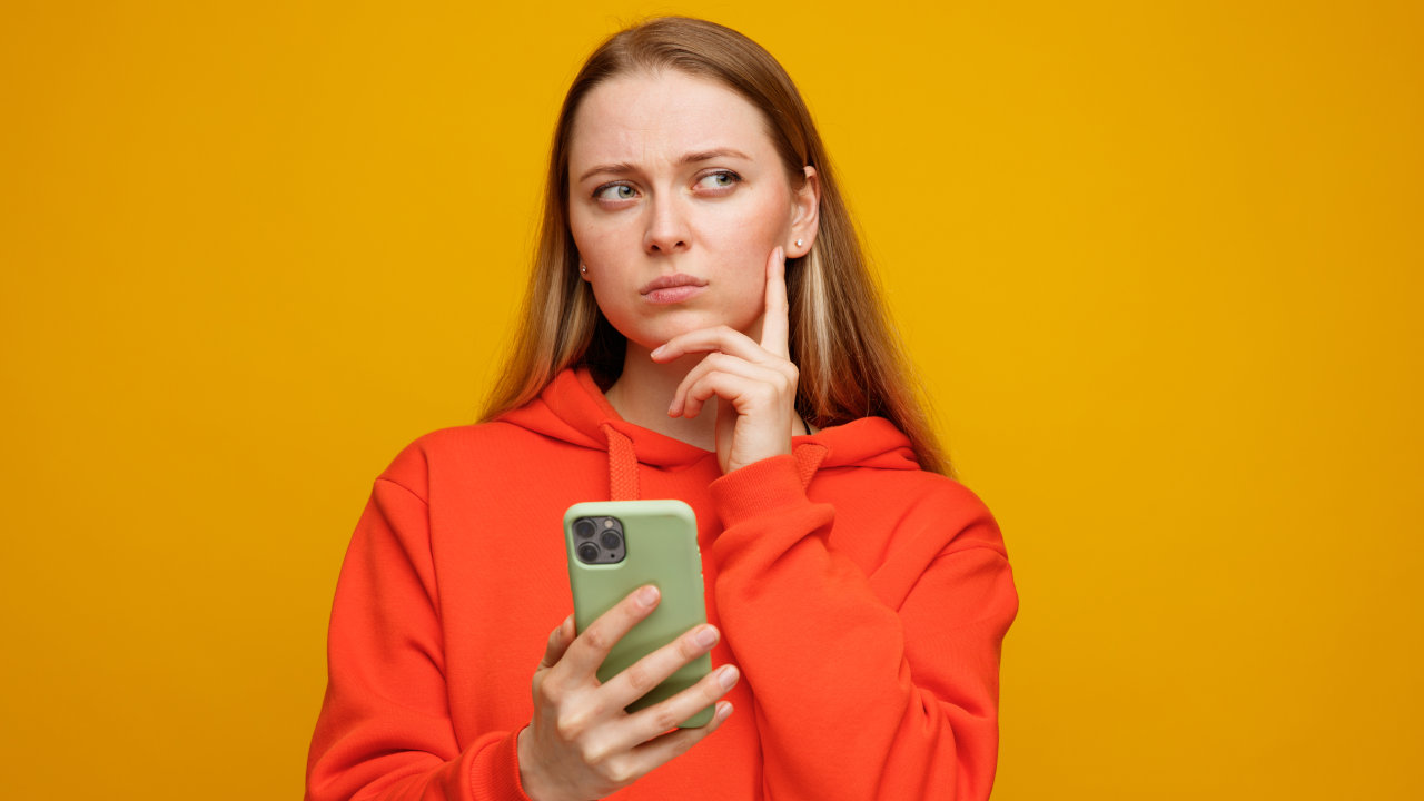 Mulher jovem com dúvida sobre qual o melhor celular para comprar Black Friday