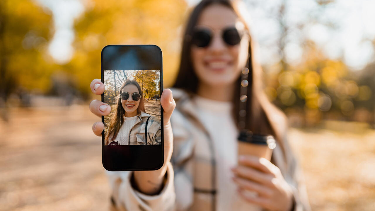 Mulher tirando foto com um celular de até 1000 reais