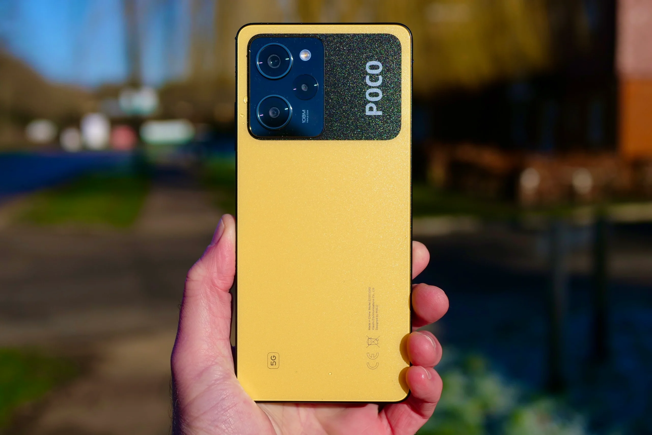 Pessoa segurando um celular Xiaomi Poco X5 Pro na cor amarela