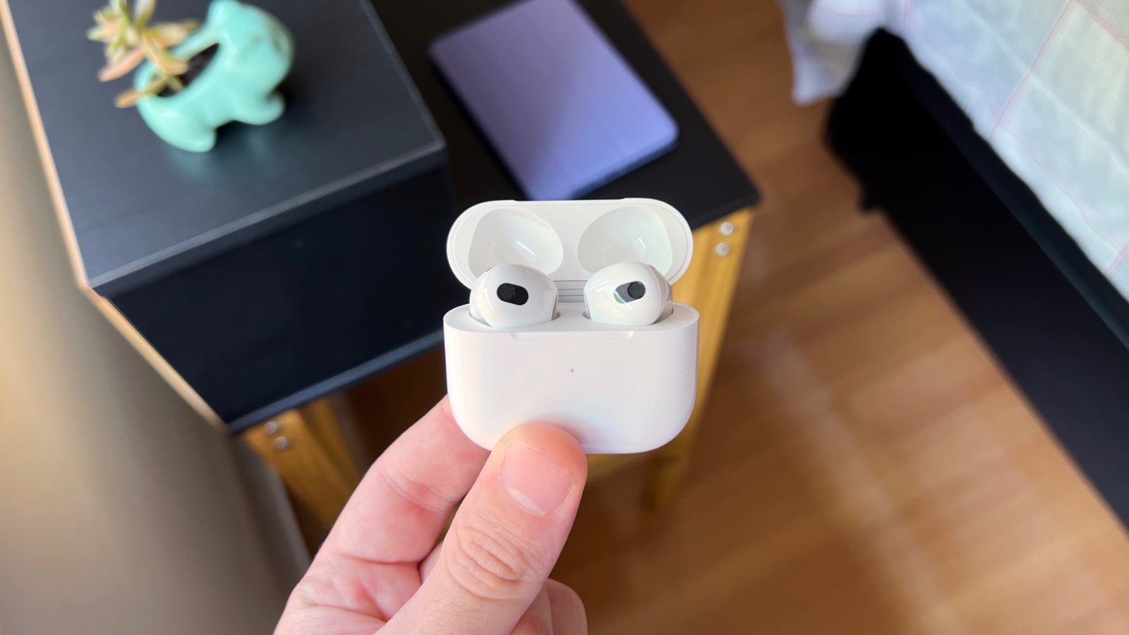 Pessoa segurando o estojo do AirPods 3ª geração na mão