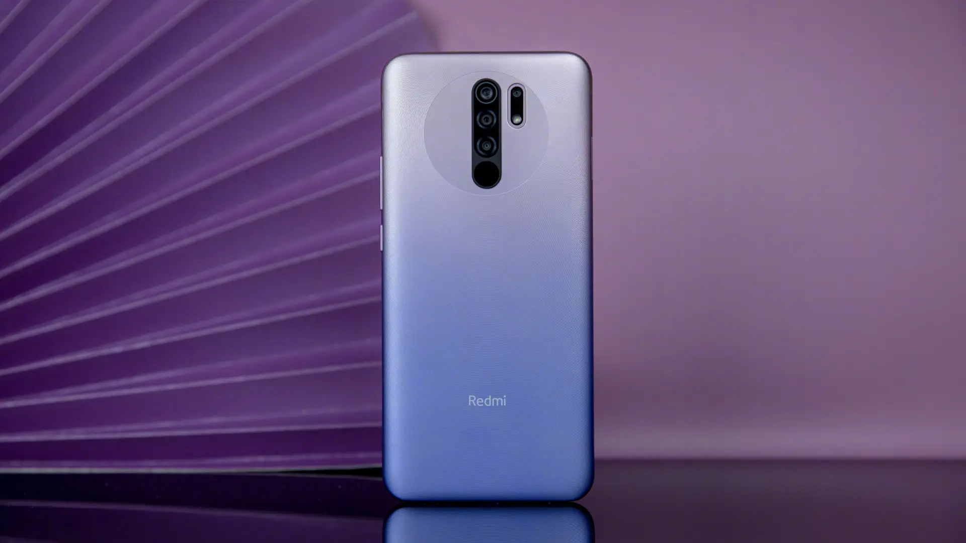 Fundo roxo destacando o celular Xiaomi Redmi 9 na cor azul