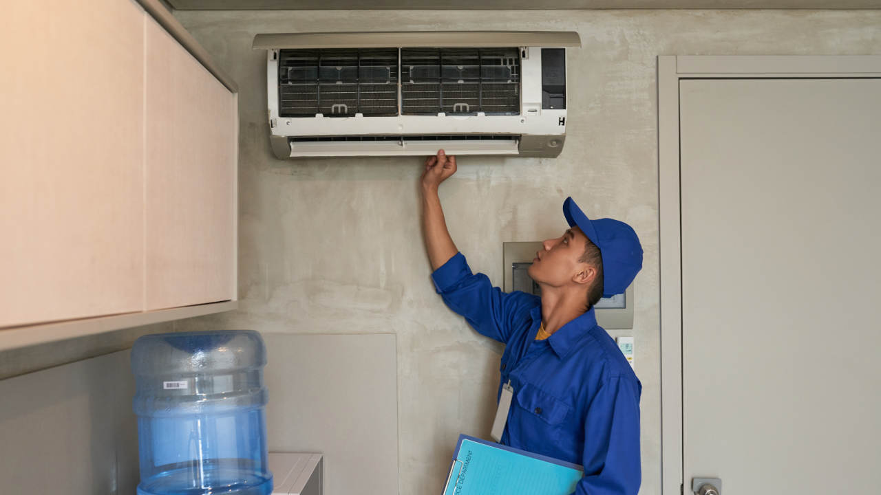 Homem instalando ar condicionado