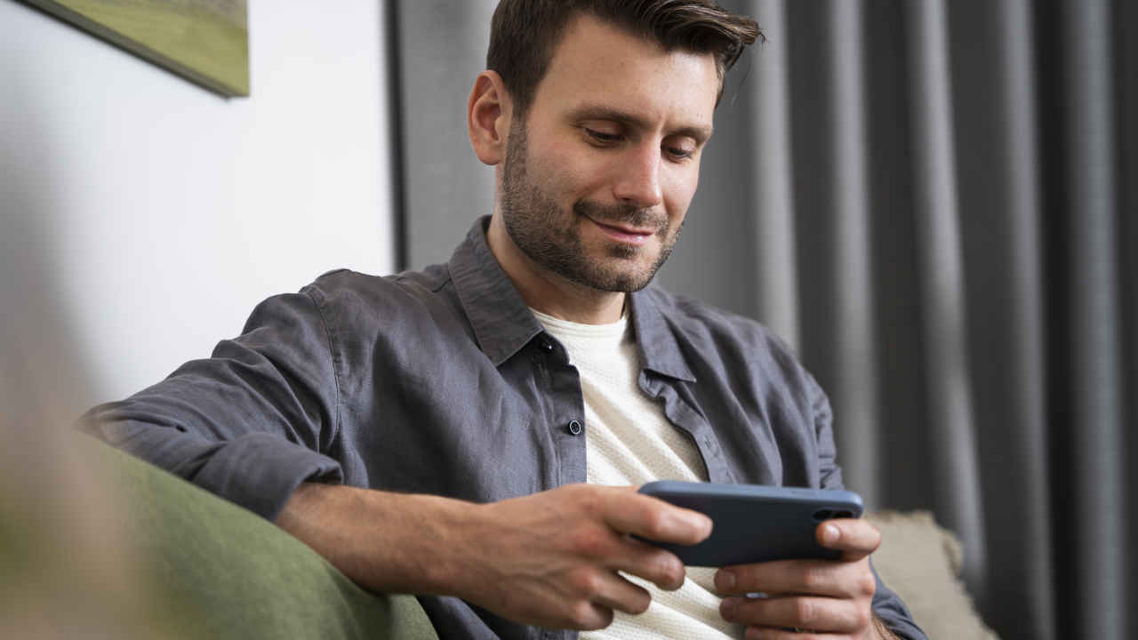 Homem assistindo globo ao vivo e grátis no celular