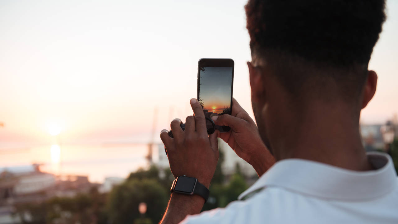 Rapaz tentando fazer foto de eclipse solar com o celular