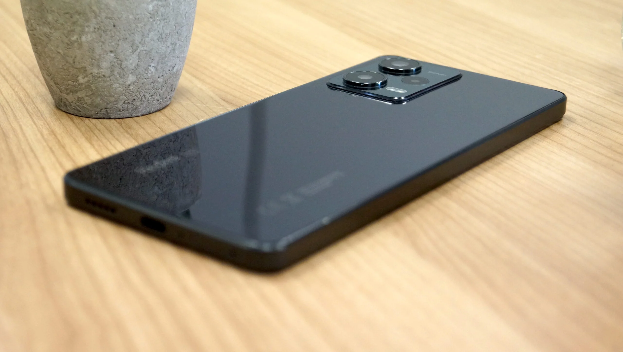 vista panorâmica do celular Xiaomi Redmi Note 12 Pro 5G na cor preta, encima de uma mesa