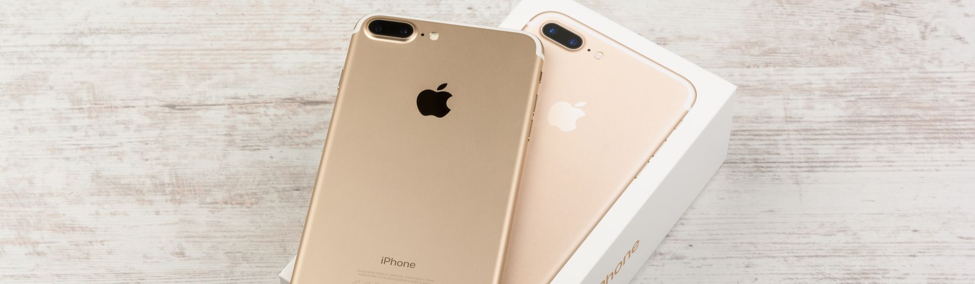 Celular iPhone 7 Plus na cor ouro sob sua embalagem