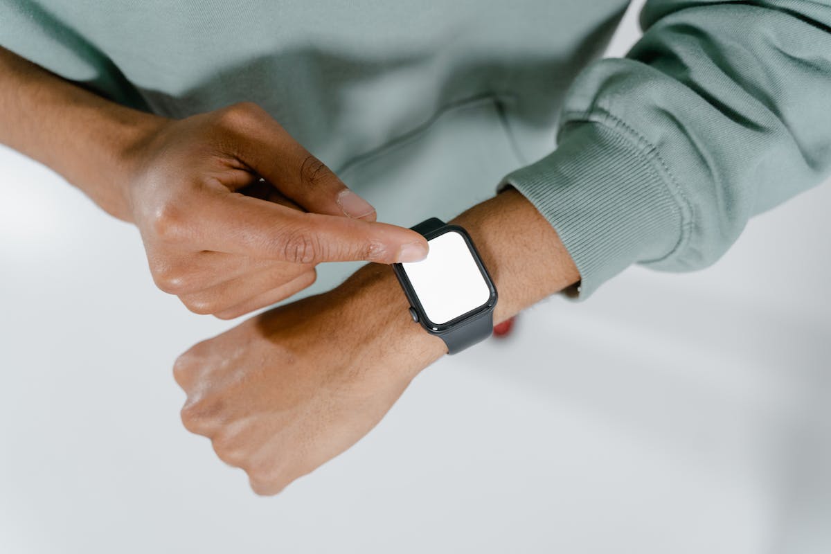 Um homem está apontando uma das falhas em smartwatches mais comuns com um aparelho no seu pulso