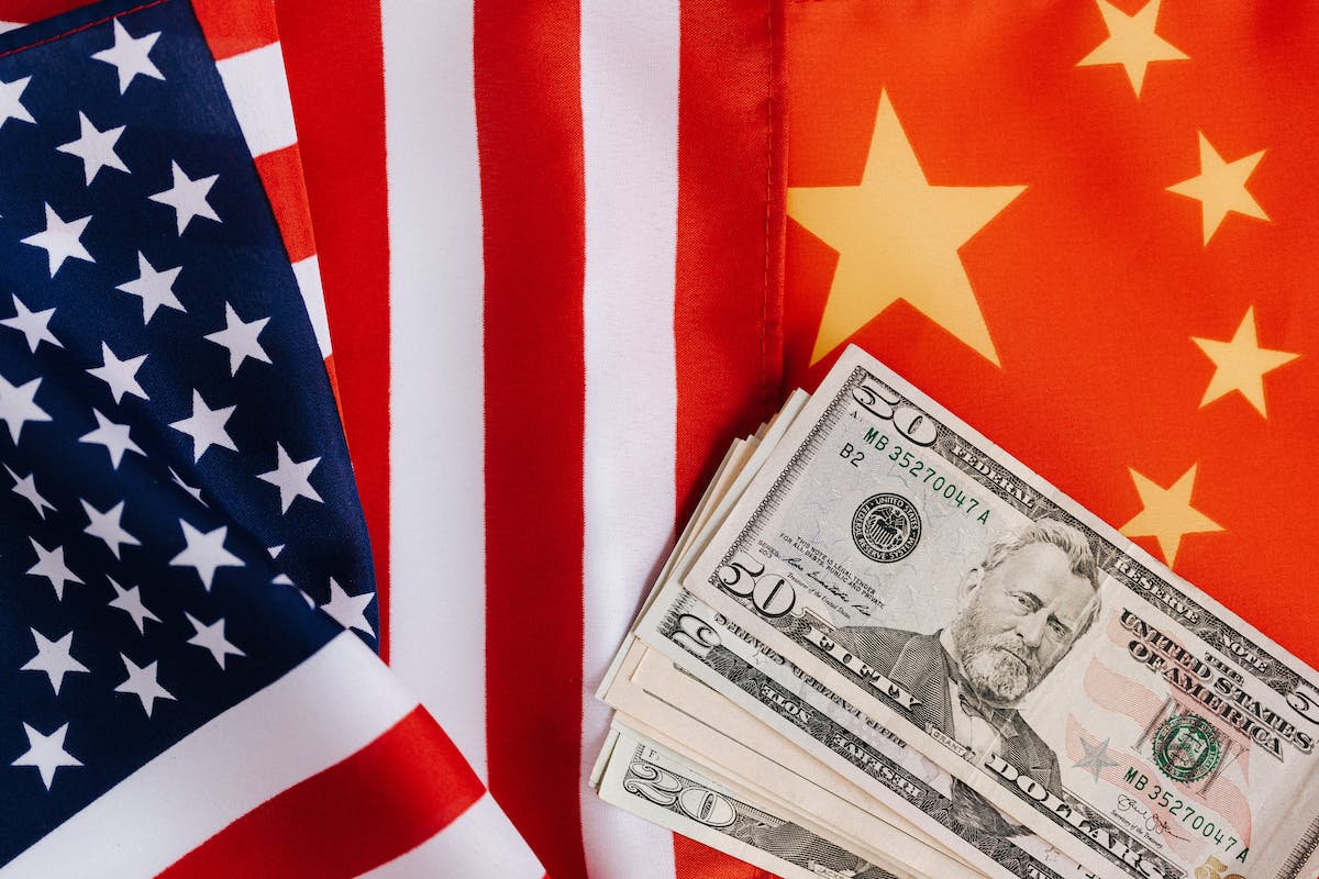 Imagem da bandeira dos EUA mesclada com a China e alguns dólares por cima