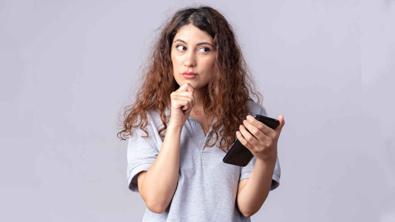 Mulher jovem com dúvida sobre celular bom e barato para comprar em 2023