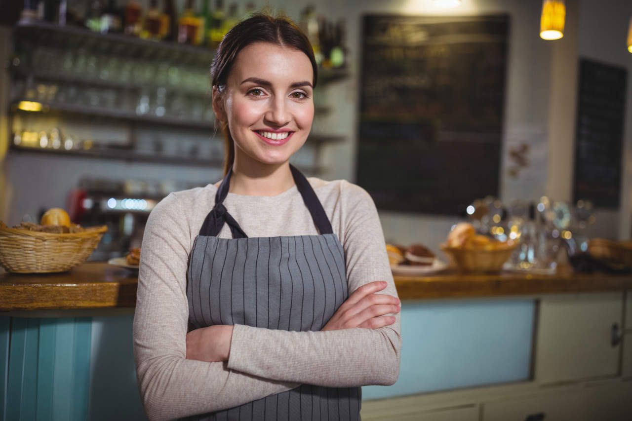 Empreendedora parada com os braços cruzados sorrindo