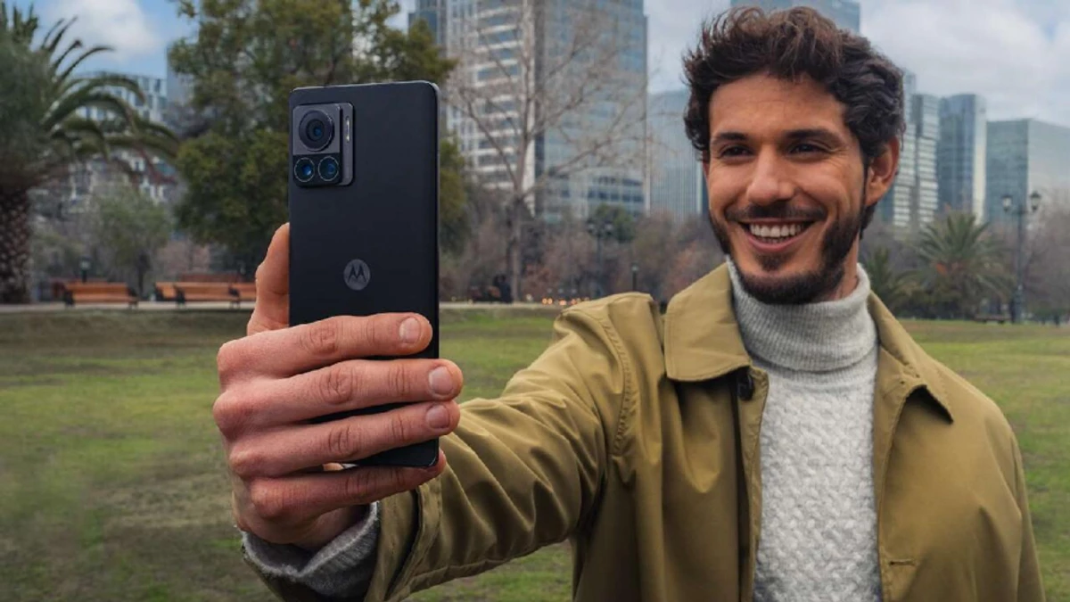 Homem tirando uma selfie em um parque, usando o celular Motorola Edge 30 8Gb 128Gb Dual Sim na cor prets