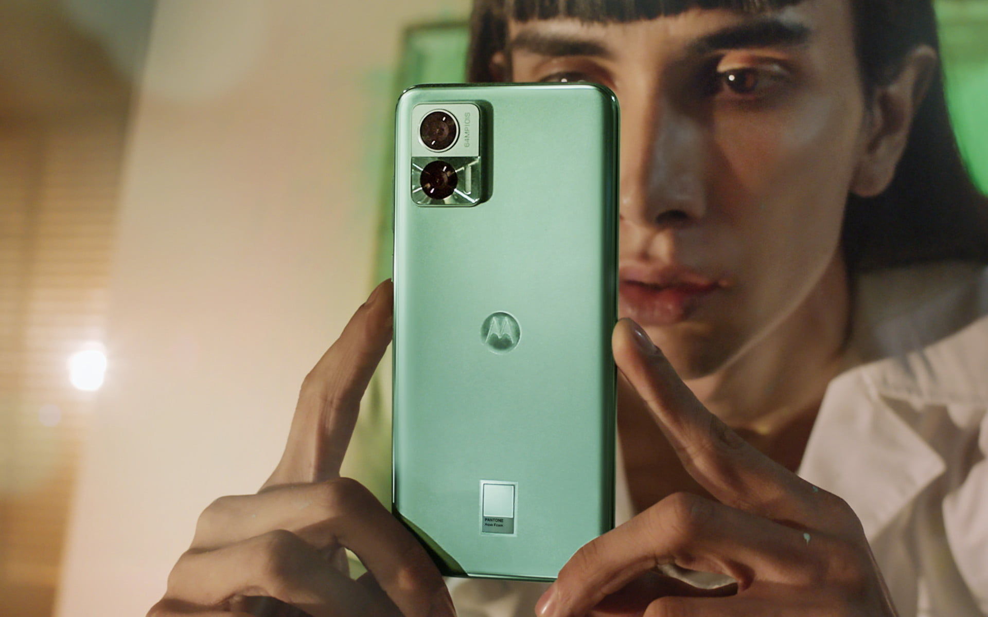 Moça fotografando com um celular Moto Edge 30 Neo na cor verde