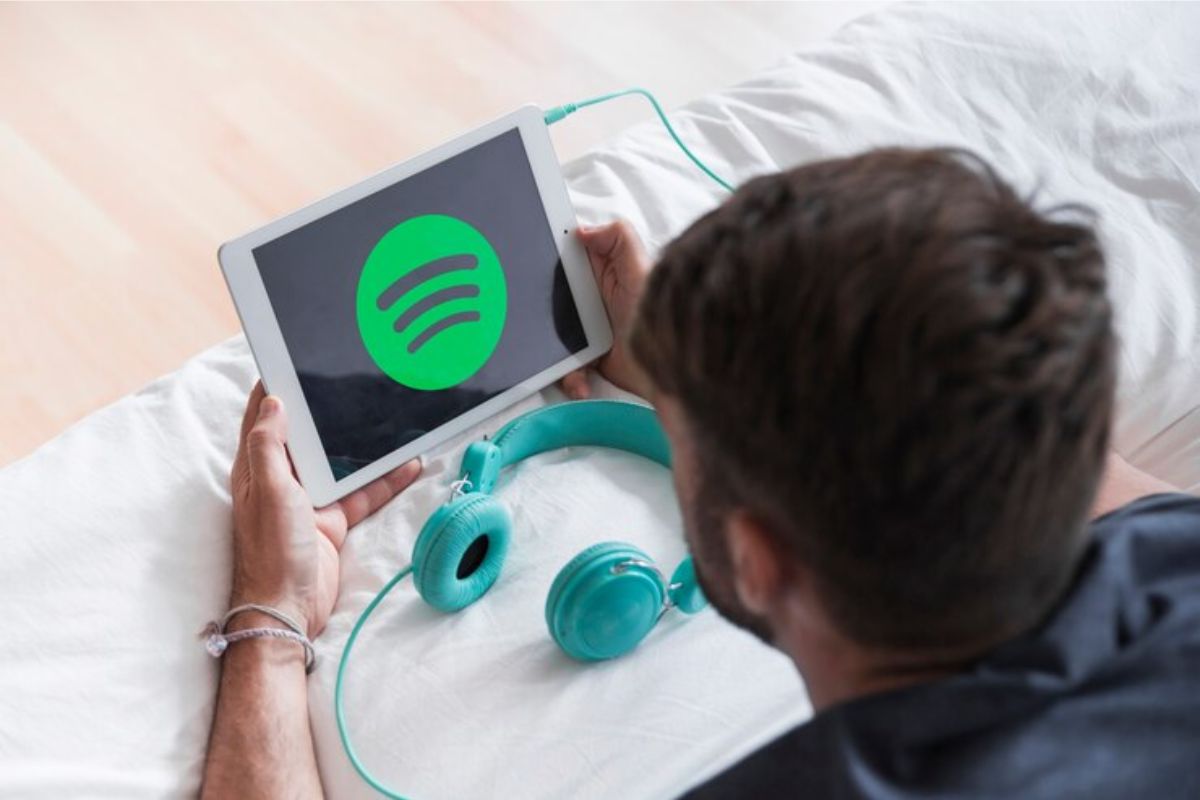 Uma mulher segura um tablet onde aparece o símbolo do Spotify