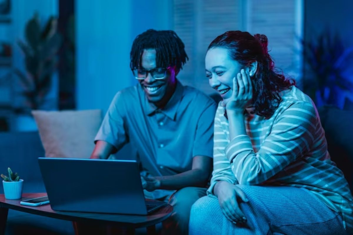 Um casal vendo filme no notebook após ver Como Instalar 9UHD Max no PC