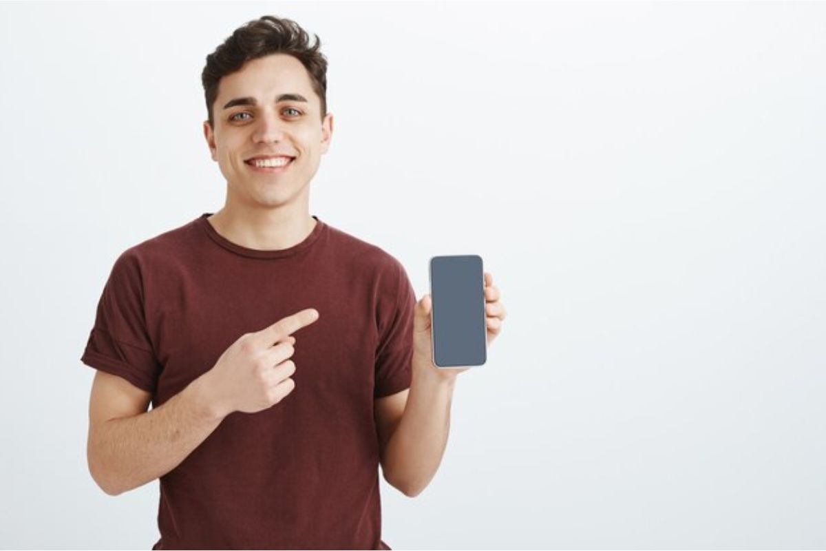 Um homem está apontando para Qual iPhone Comprar em 2024?