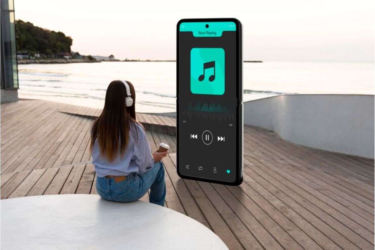 Uma mulher está sentada e na sua frente há um grande celular de pé tocando músicas de sua Retrospectiva Apple Music 2023