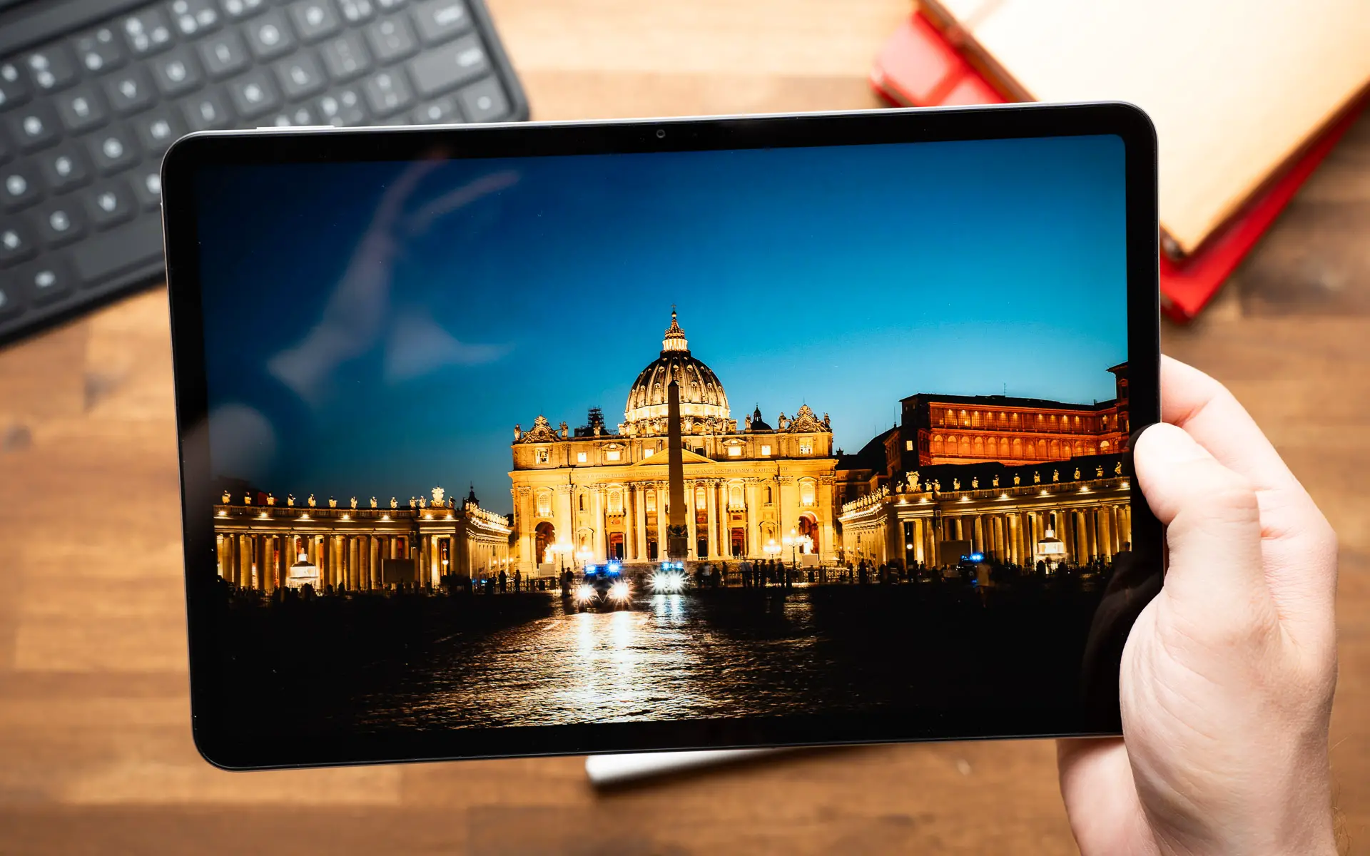Pessoa segurando o tablet Xiaomi X Pad Pro Max, com a tela virada para frente, mostrando um ponto turístico de Roma