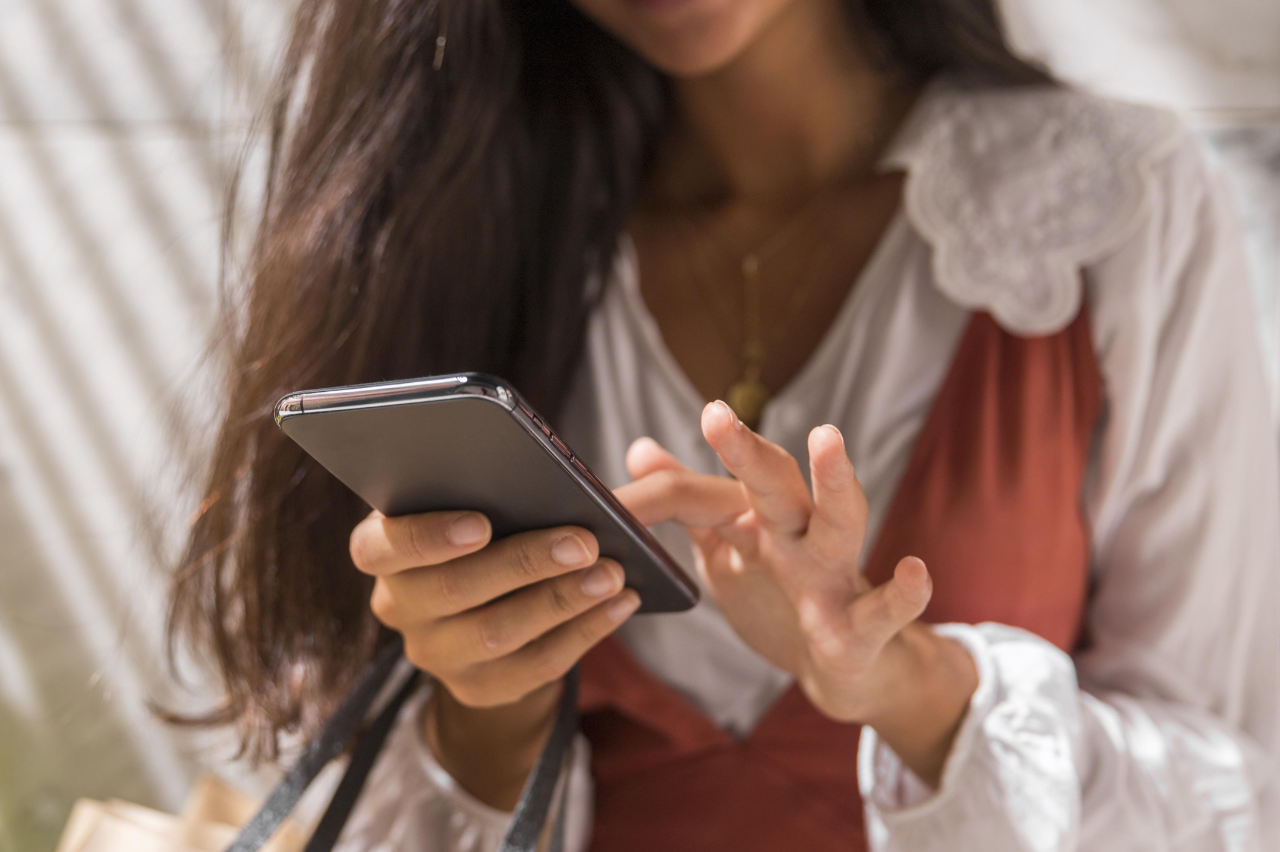 Mulher mexendo no celular enquanto faz compras