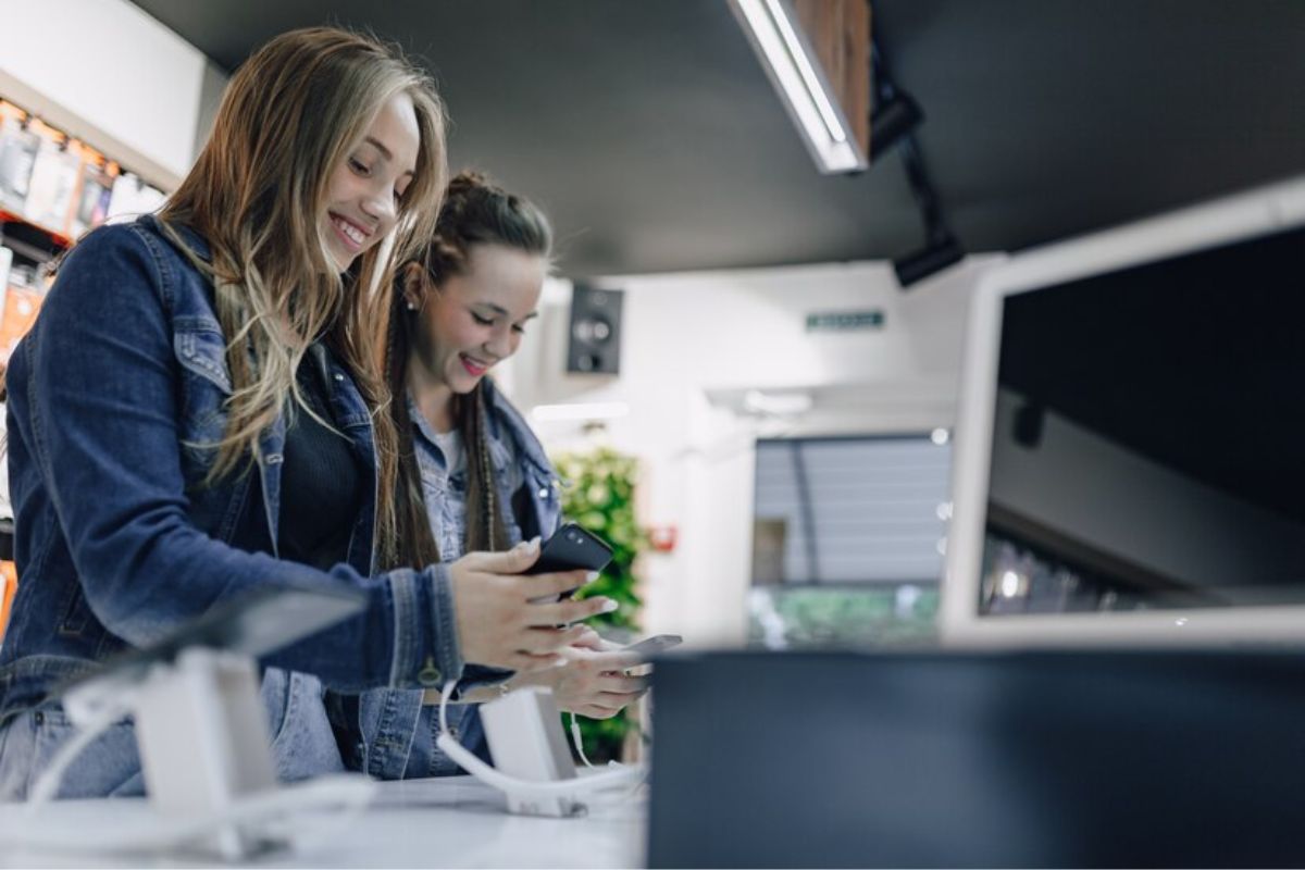 Duas mulheres estão em uma loja de tecnologia comprando o