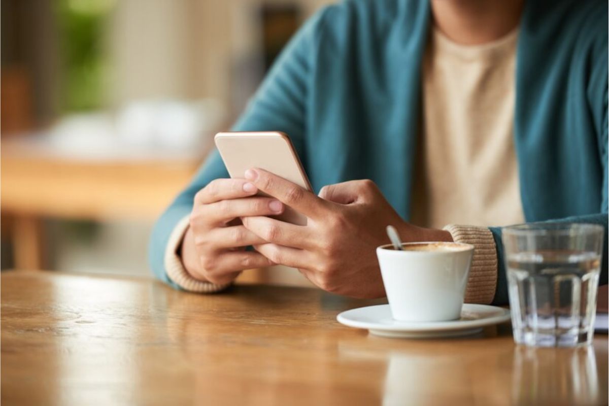 Uma mulher está mexendo no seu smartphone vendo Como Fazer um Currículo pelo Celular