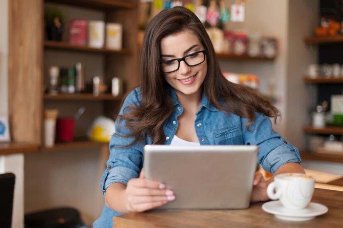 Uma mulher usando o tablet para ler notícias