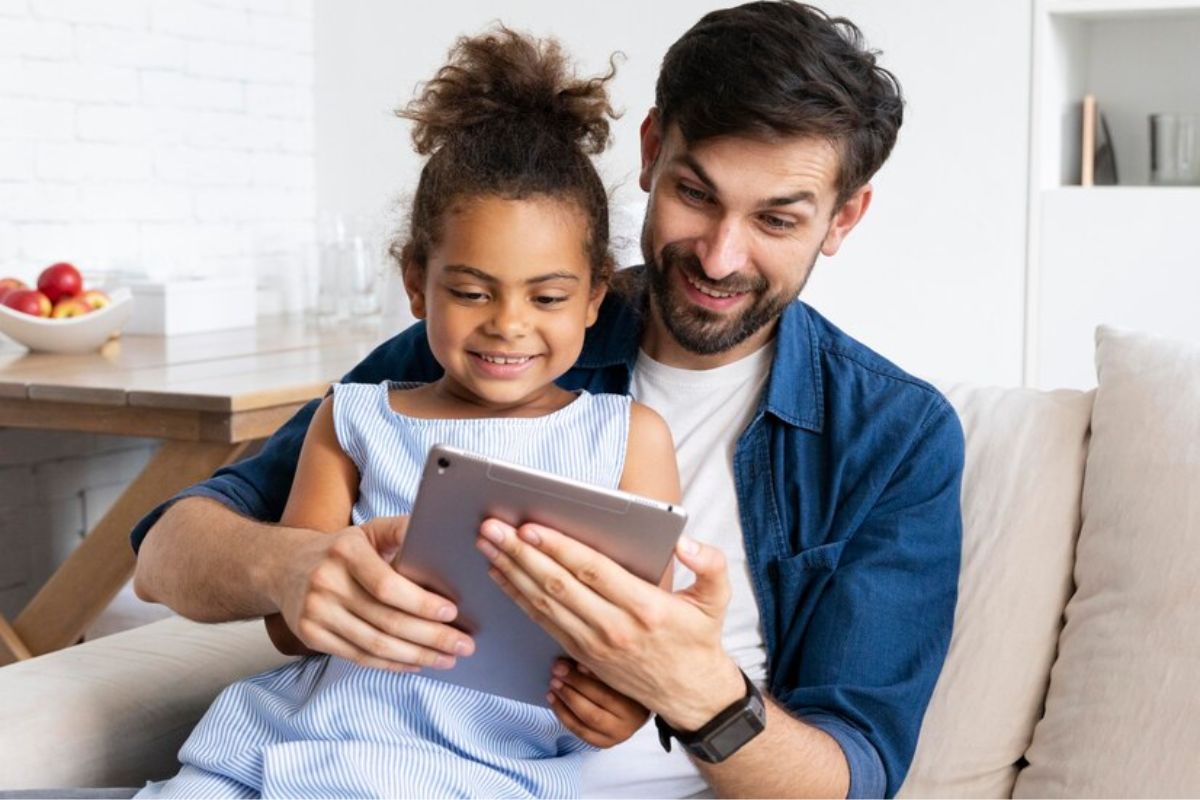 Um pais com sua filha no colo usa um Tablet S6