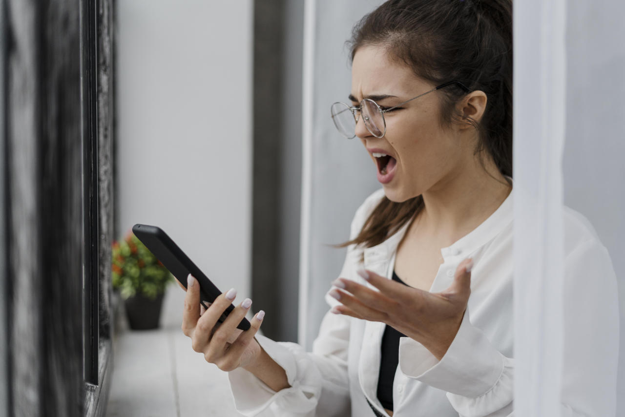 Garota frustrada com celular na mão