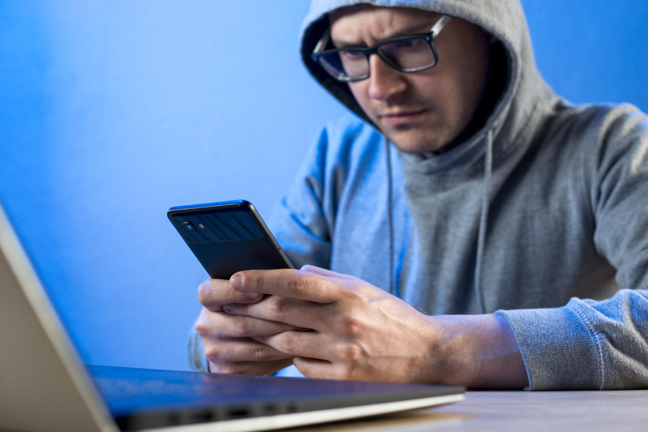 Jovem nerd com celular na mão