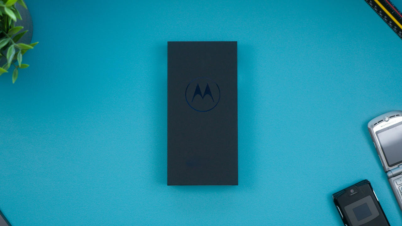 Caixa de um dos melhores celulares da Motorola em cima de uma mesa azul