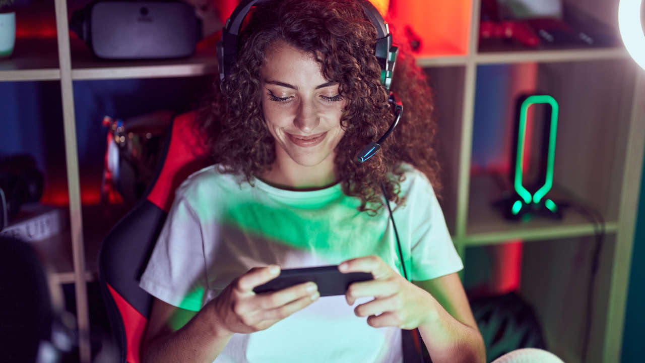 Jovem jogando os melhores jogos de 2025 em um celular