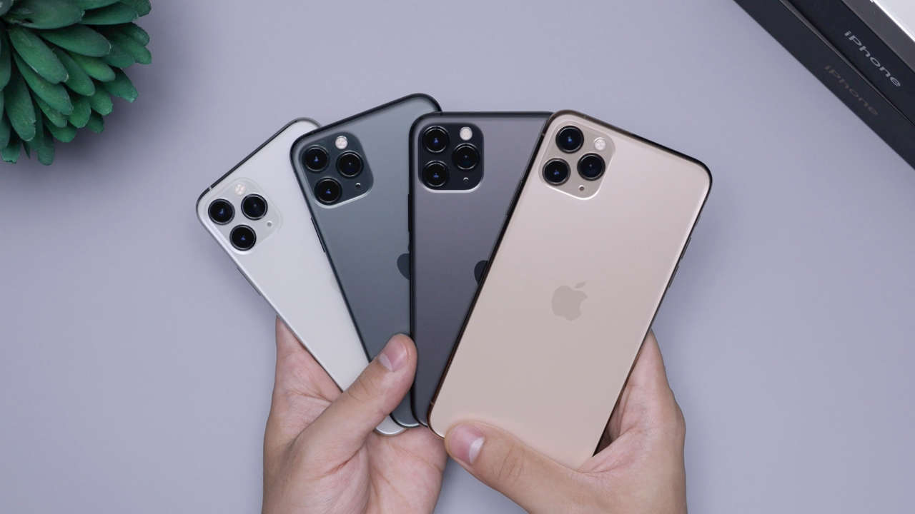 Mãos segurando diversos iPhones. Qual comprar em 2025?