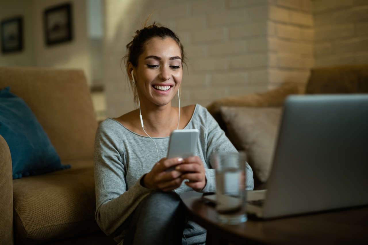 Mulher feliz usando aplicativo no celular para ganhar dinheiro