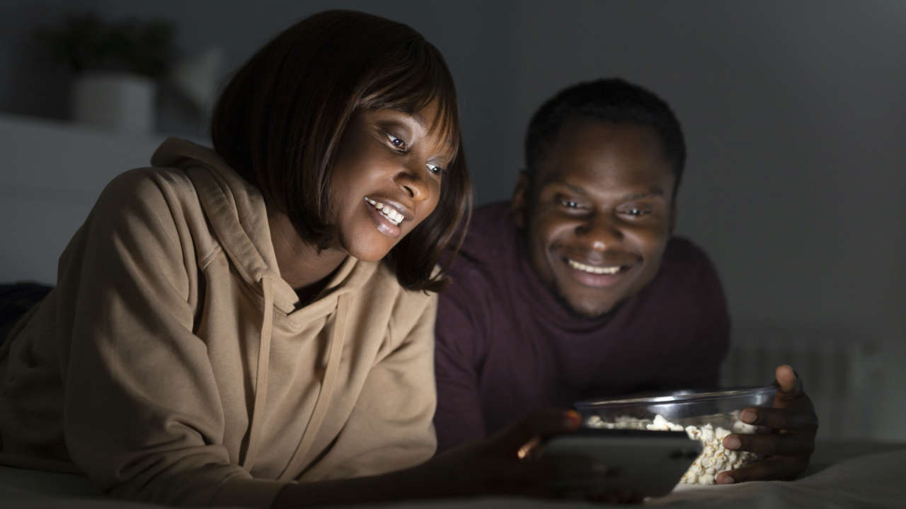 Casal negro assistindo TV online no celular