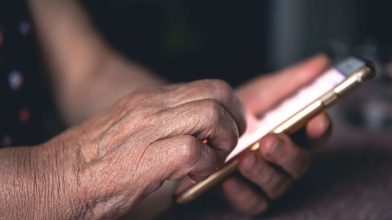 Celular nas mãos de pessoa idosa