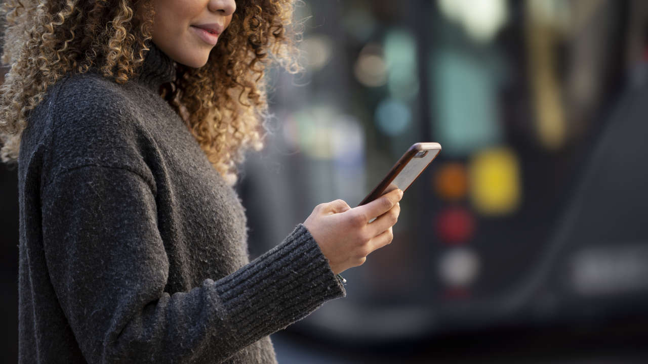 Mulher usando um dos melhores celulares de entrada na rua