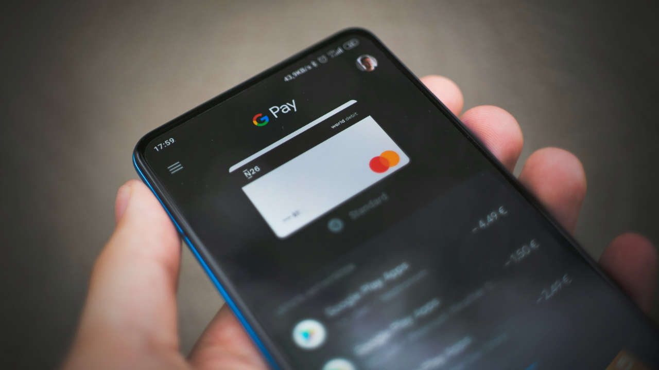 Pessoa com Google Pay no celular, aplicativo que permite pagar por aproximação