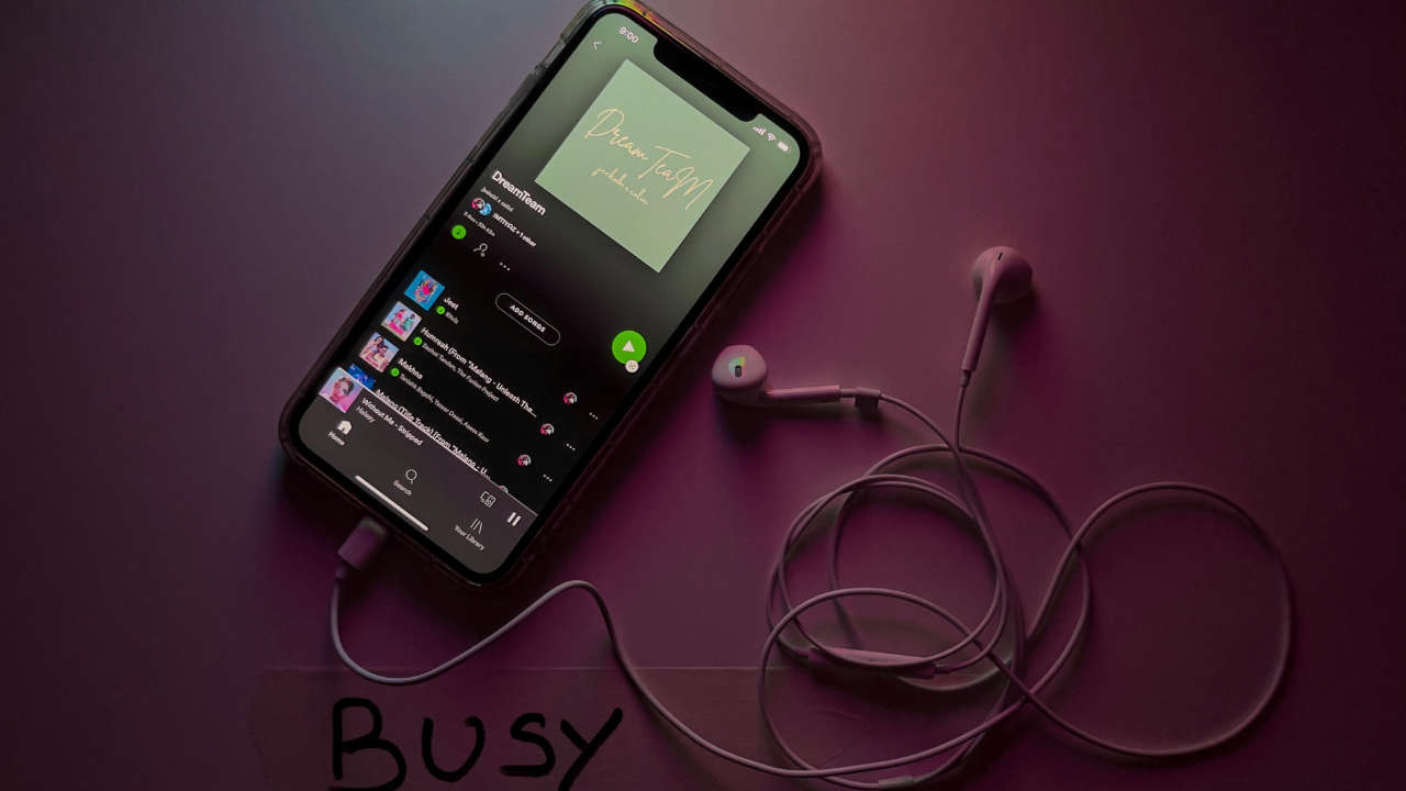 Celular conectado em fones de ouvido enquanto toca música no Spotify