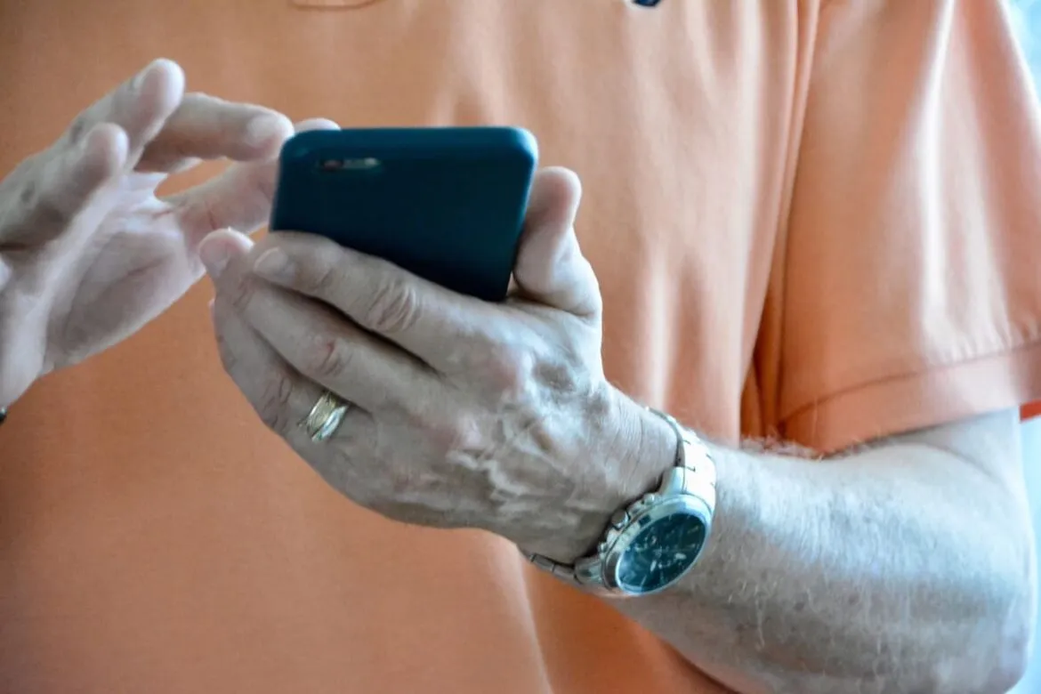 Homem segurando um celular na mão