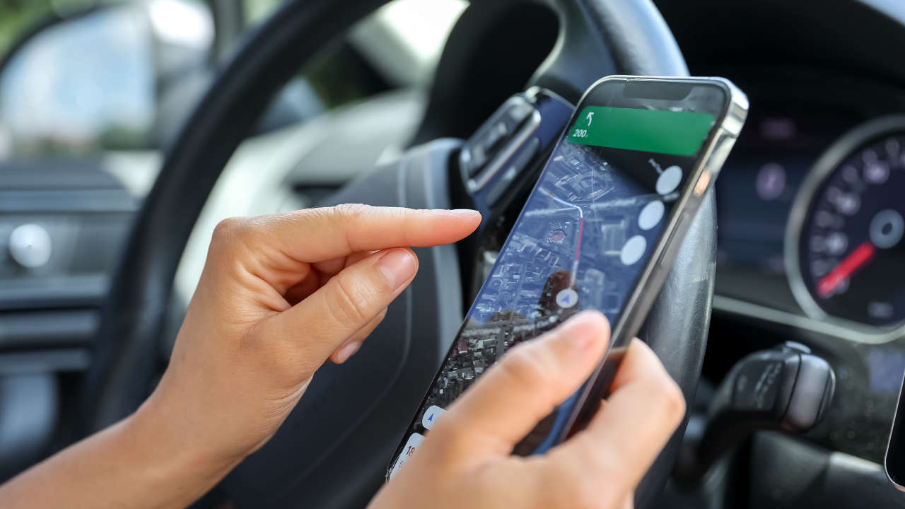 Motorista segurando celular com aplicativo de mapa