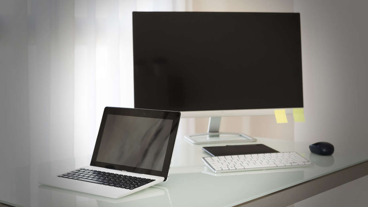 Sistema com notebook e segunda tela em cima de uma mesa